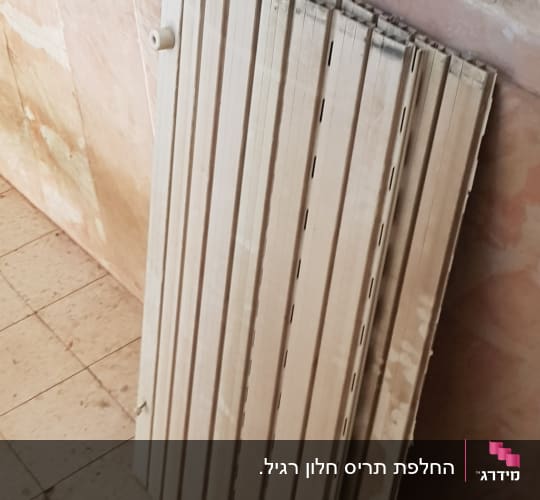 תריסים מונחים על הרצפה ליד קיר
